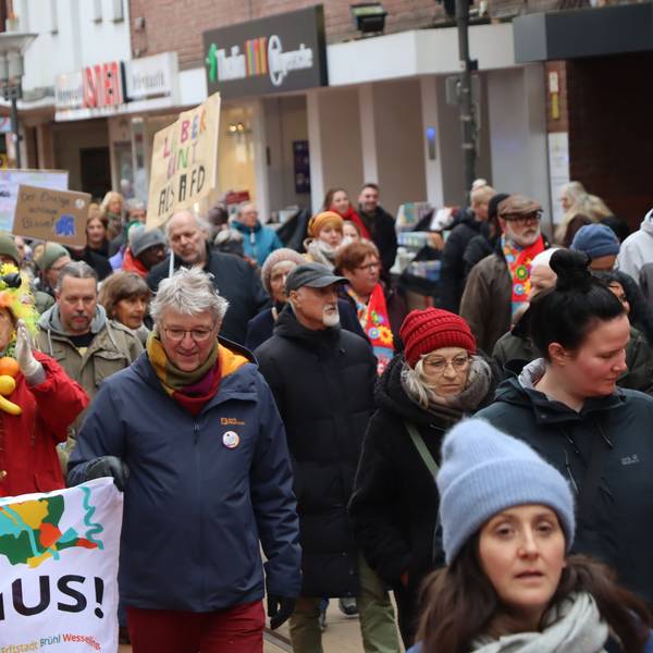 Auf dem Foto sind Demonstranten mit bunter Kleidung und Plakaten zu sehen.
