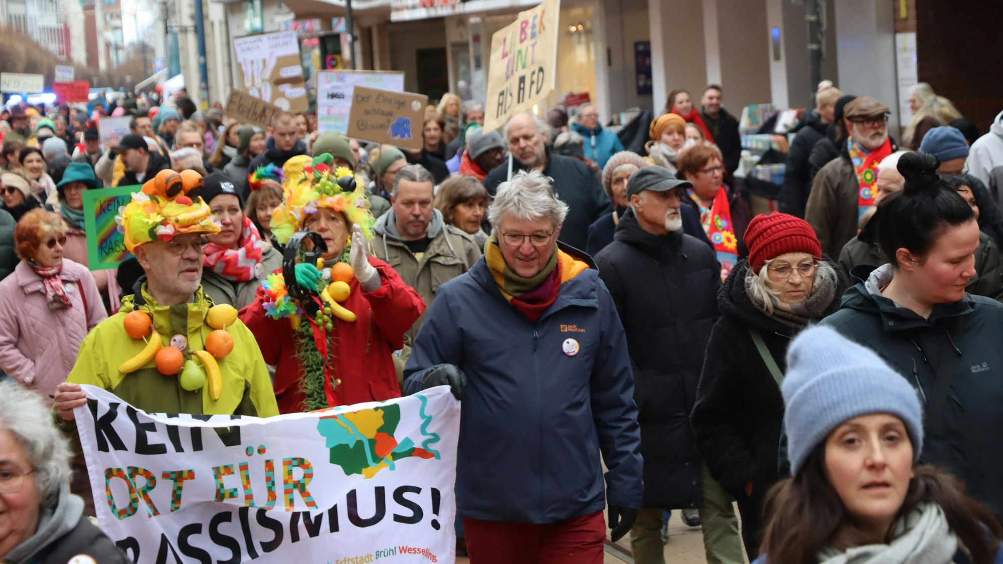 Auf dem Foto sind Demonstranten mit bunter Kleidung und Plakaten zu sehen.