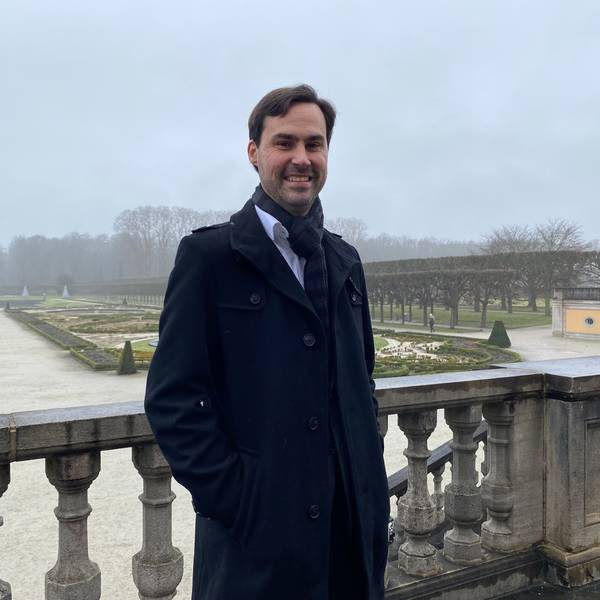 Markus Hausmann steht auf einer Terrasse, im Hintergrund ist der Schlosspark im Brühl zu sehen.