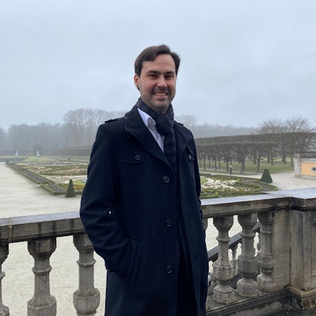 Markus Hausmann steht auf einer Terrasse, im Hintergrund ist der Schlosspark im Brühl zu sehen.