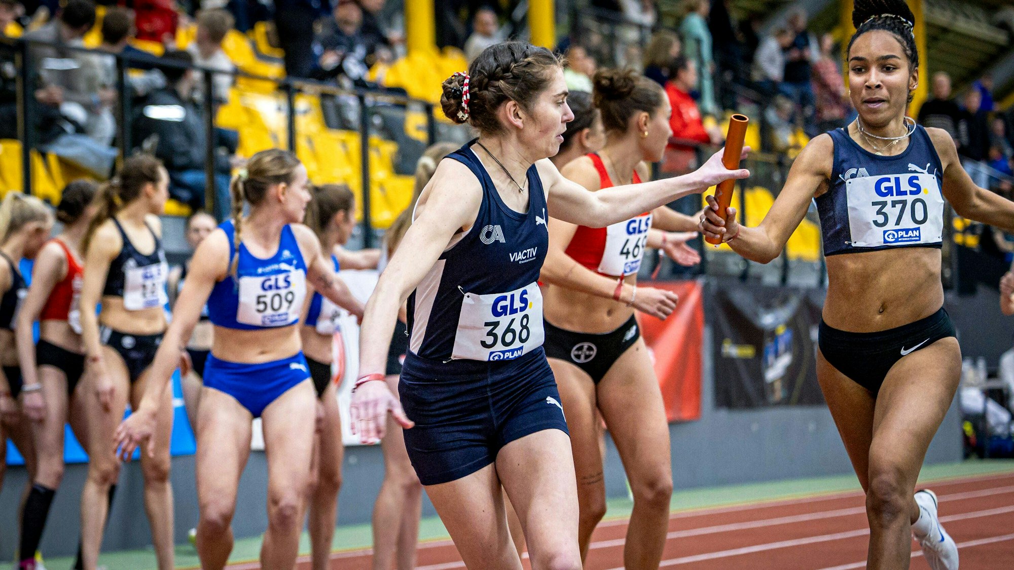 Natalie Füllgraf von den Cologne Athletics übergibt den Staffelstab in Führung liegend an Vera Coutellier, die den Vorsprung ins Ziel bringt.