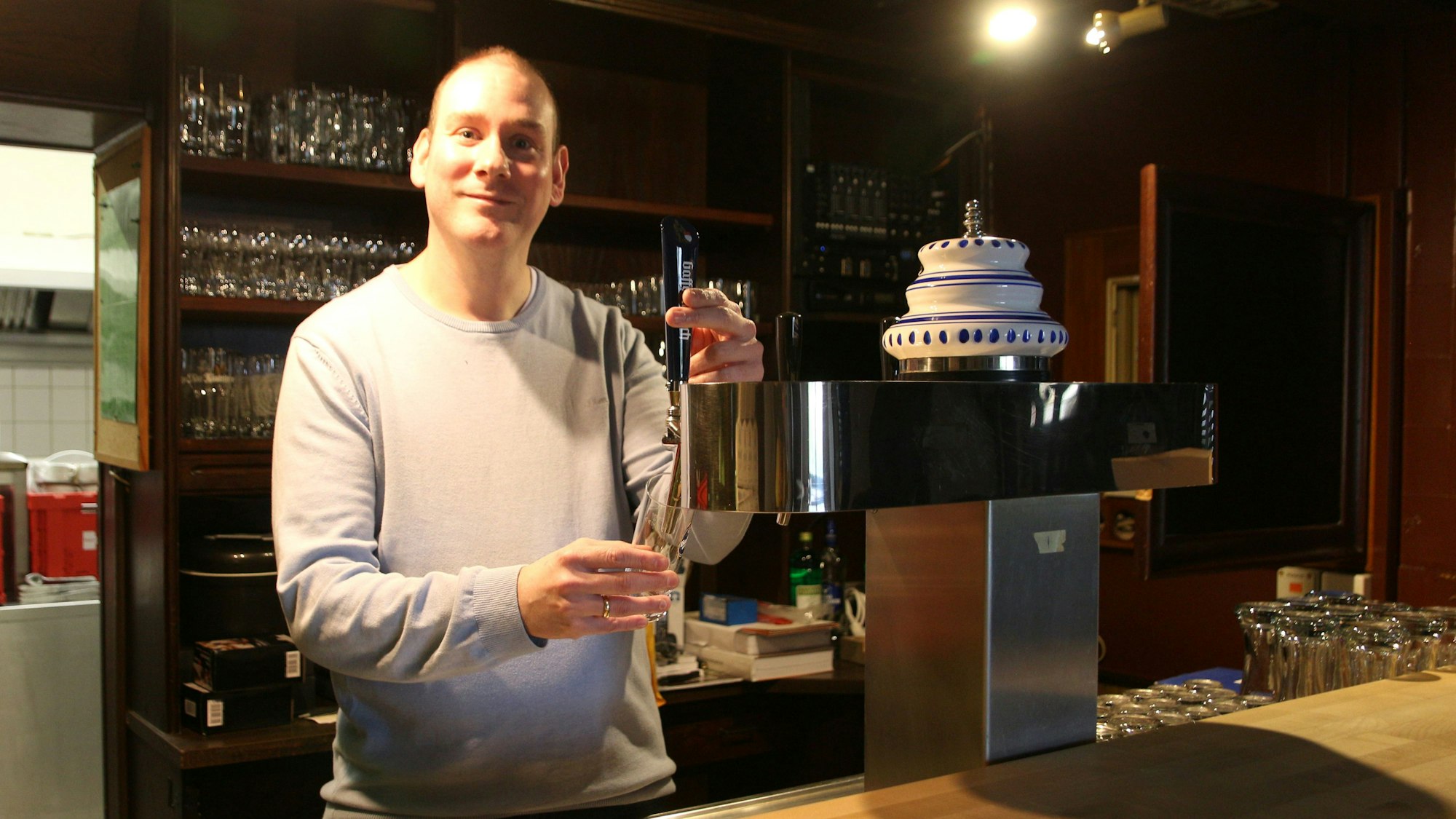 Auf dem Bild ist ein Mann an einem Zapfhahn am Tresen zu sehen.