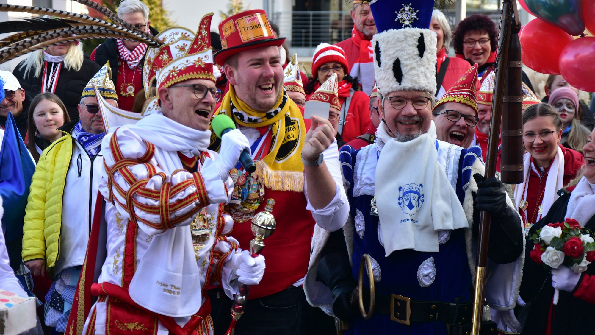 Menschen in Karnevalskostümen, vorne ein Karnevalsprinz und der Bauer aus einem Dreigestirn.