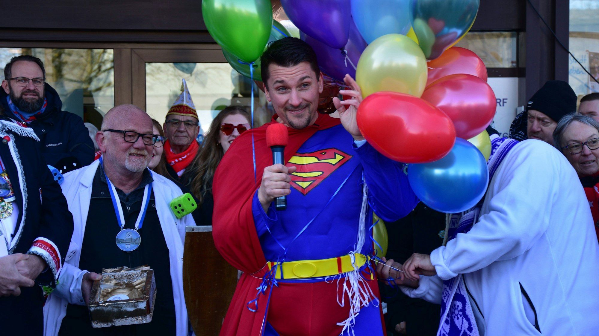 Ein Mann mit Mikrofon in einem Superman-Kostüm.