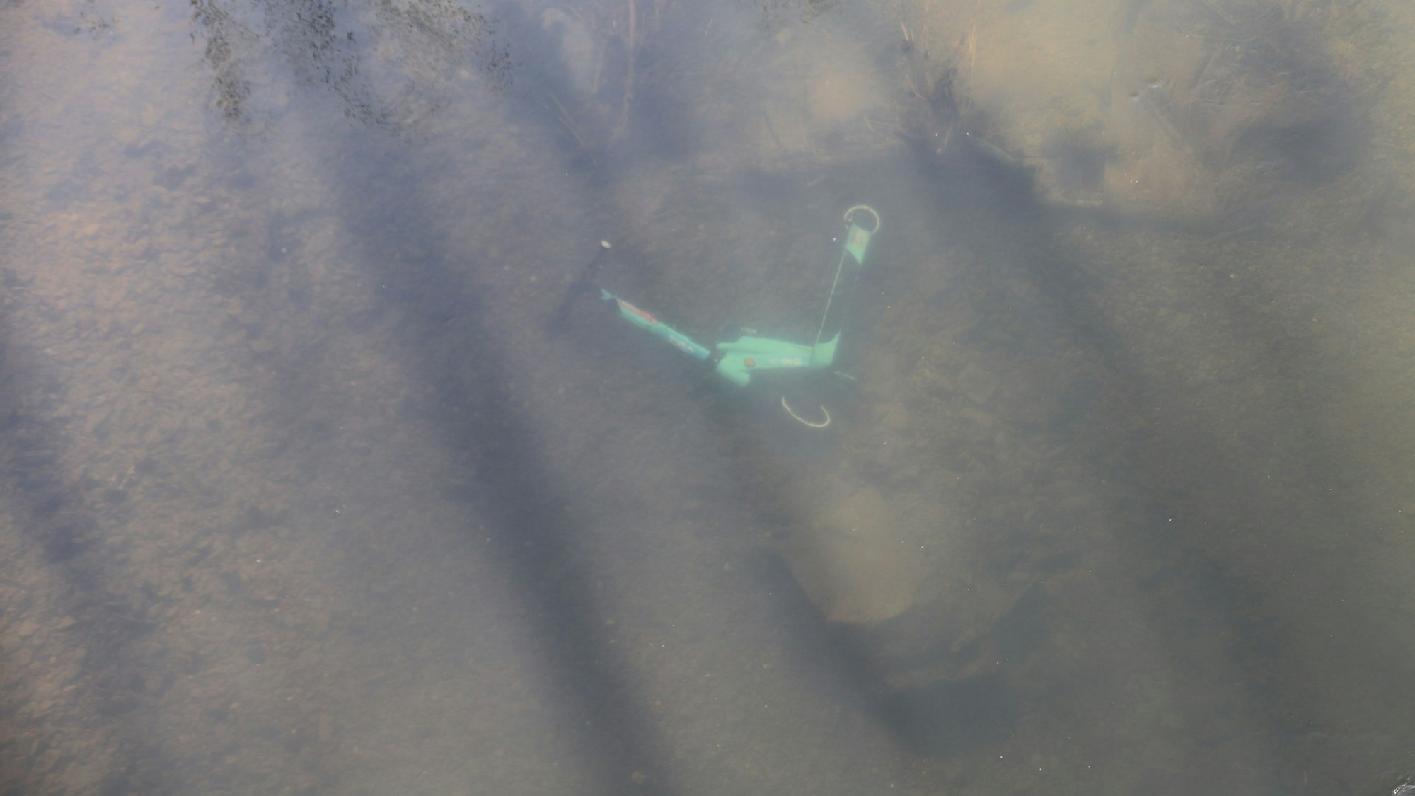Ein E-Scooter liegt unter Wasser.