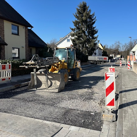 Die Baustelle auf Uhlandstraße ärgert die Geschäftsleute. Ein Bagger steht herum, die Straße ist aufgerissen.