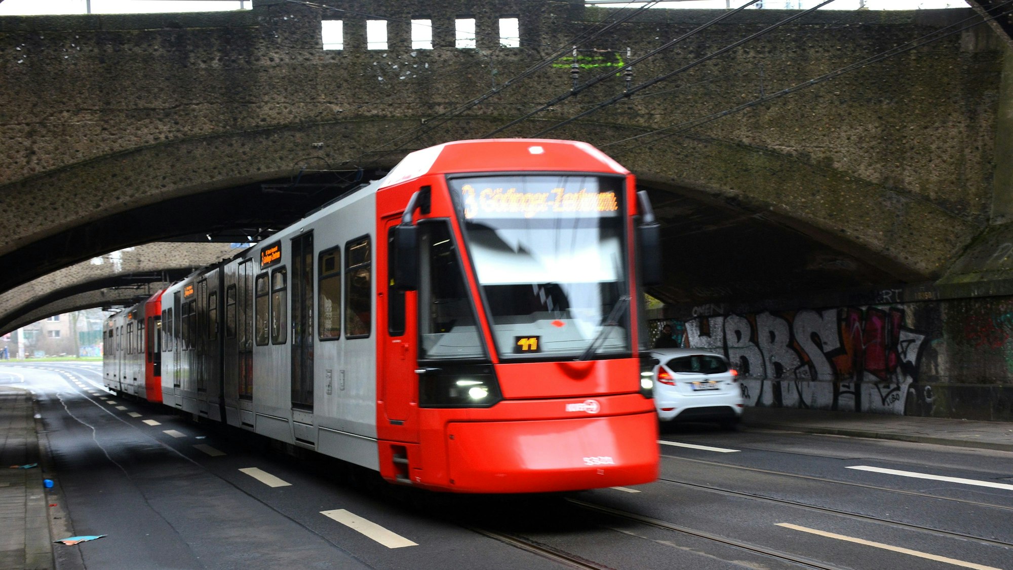 Eine KVB-Bahn unterquert eine Eisenbahnbrücke.