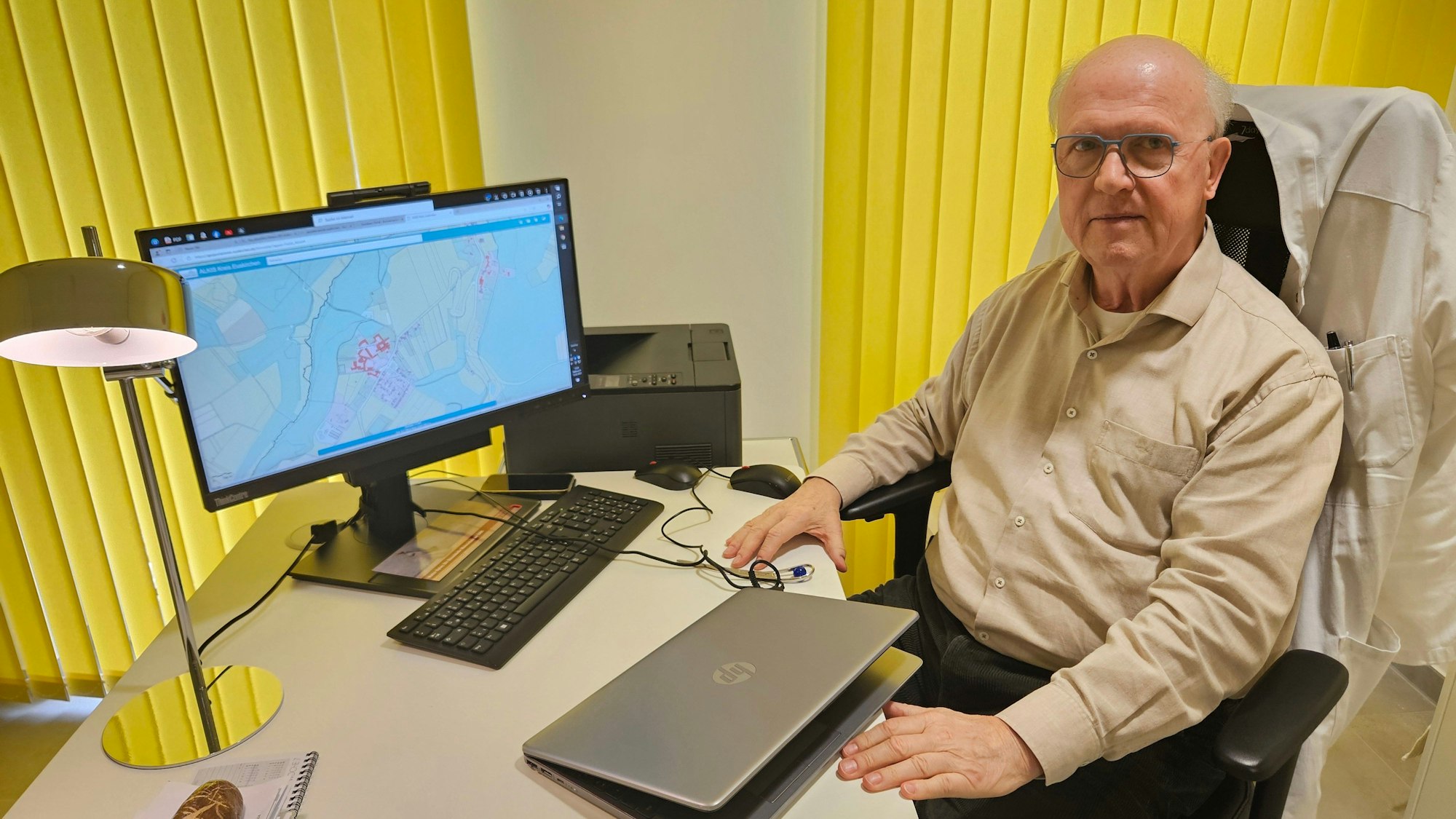 Albert Halling sitzt an seinem Schreibtisch in seiner Praxis.