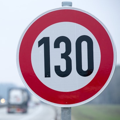 An der Autobahn steht ein Verkehrsschild mit der Geschwindigkeitsangabe von 130 km/h.