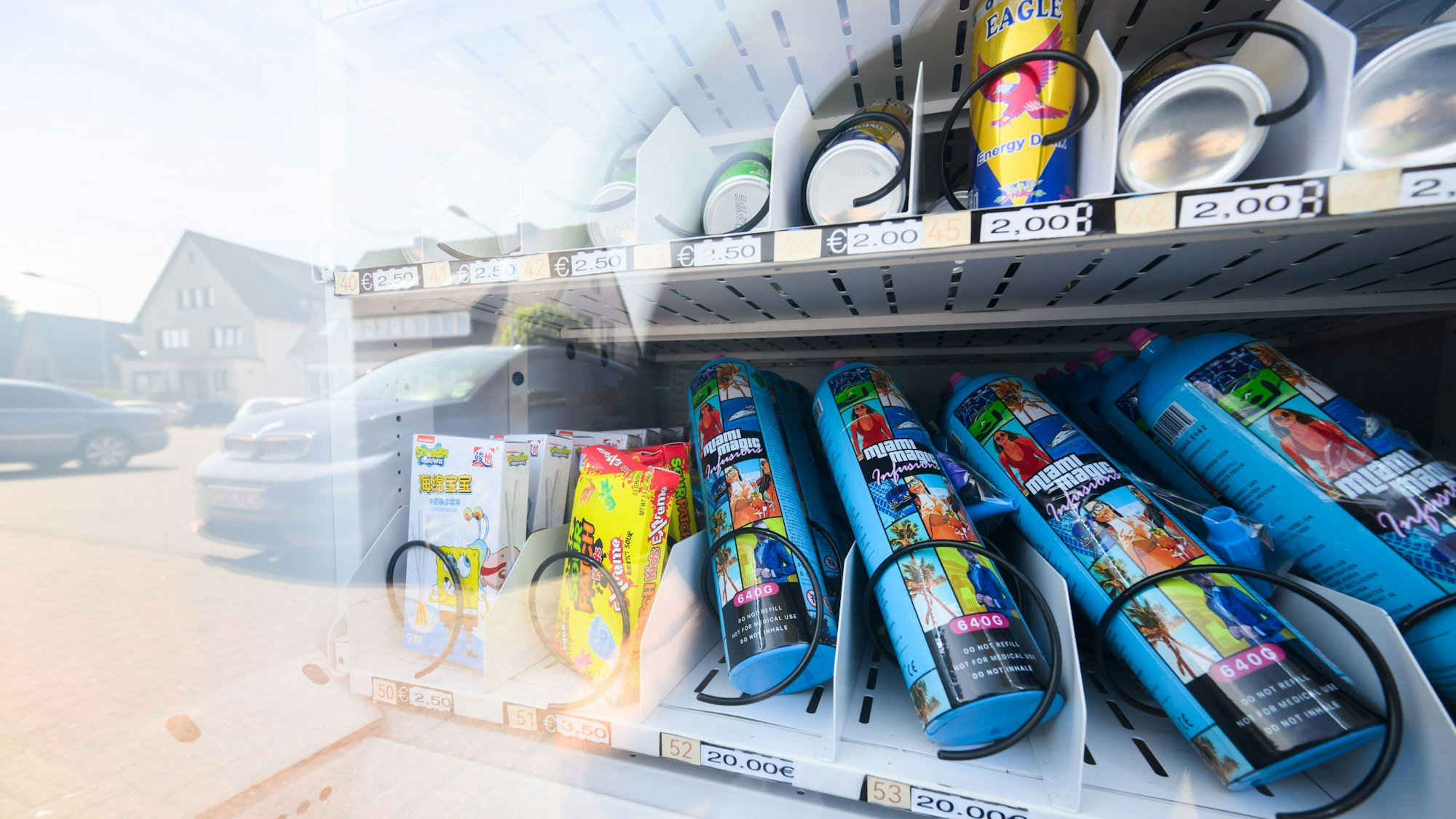 Ein Warenautomat, unter anderem mit Lachgasflaschen bestückt, steht vor einem Ladengeschäft.