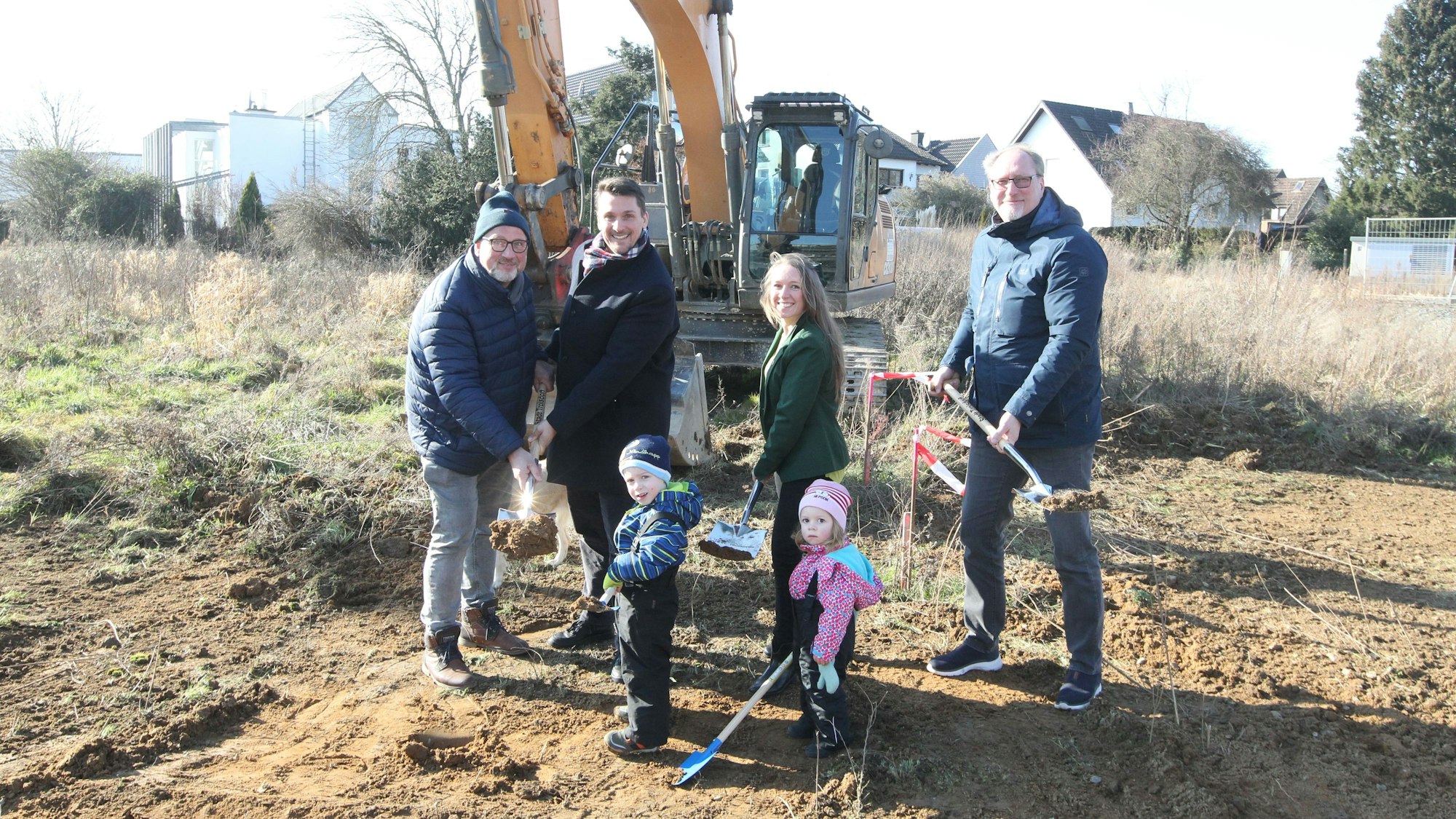 Spatenstich für die neue Kindertagesstätte im Neubaugebiet ‚Auf dem Grend‘ in Sieglar mit v.l. Bauunternehmer Jörg Schenkelberg, Bürgermeister Alexander Biber, Investorin Sarah Schenkelberg und ihren Kindern Matteo und Mia sowie Jugendamtsleiter Markus Wüst