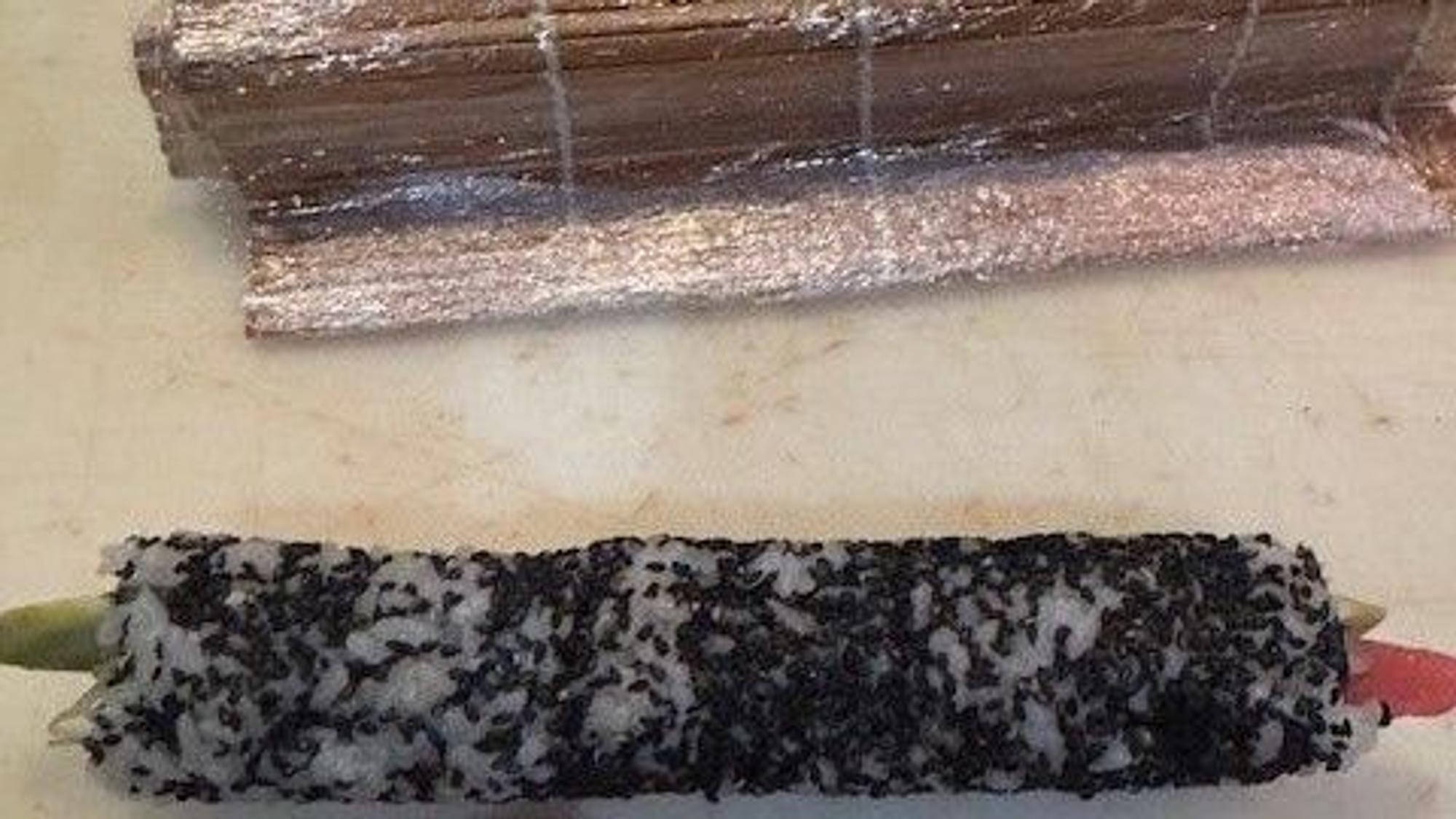 Matte aufrollen, mit dem Cellophan entfernen, Tuna Roll in Stücke schneiden.