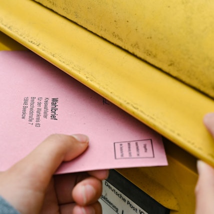 ARCHIV - 19.09.2021, Brandenburg, Sieversdorf: Eine Person wirft ihre Briefwahlunterlagen in einen Postkasten der Deutschen Post. (zu dpa: «Bundestags-Briefwahl: Post appelliert zum baldigen Einwurf») Foto: Patrick Pleul/dpa-Zentralbild/dpa +++ dpa-Bildfunk +++