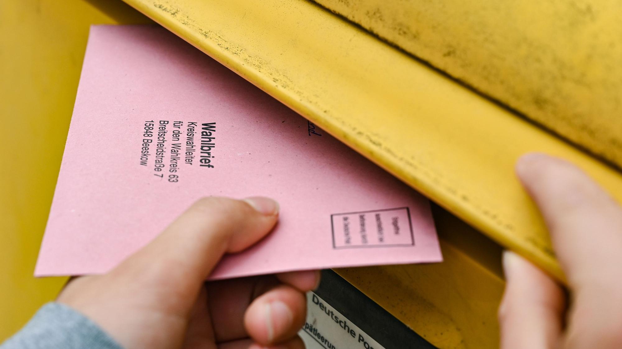 ARCHIV - 19.09.2021, Brandenburg, Sieversdorf: Eine Person wirft ihre Briefwahlunterlagen in einen Postkasten der Deutschen Post. (zu dpa: «Bundestags-Briefwahl: Post appelliert zum baldigen Einwurf») Foto: Patrick Pleul/dpa-Zentralbild/dpa +++ dpa-Bildfunk +++