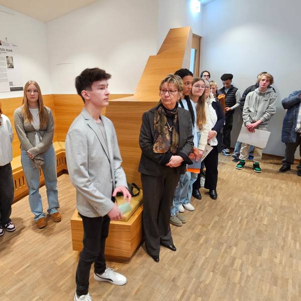 Christian Baran steht neben Silvia Löhrmann, daneben und dahinter stehen weitere Schüler.