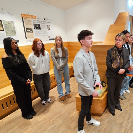 Christian Baran steht neben Silvia Löhrmann, daneben und dahinter stehen weitere Schüler.