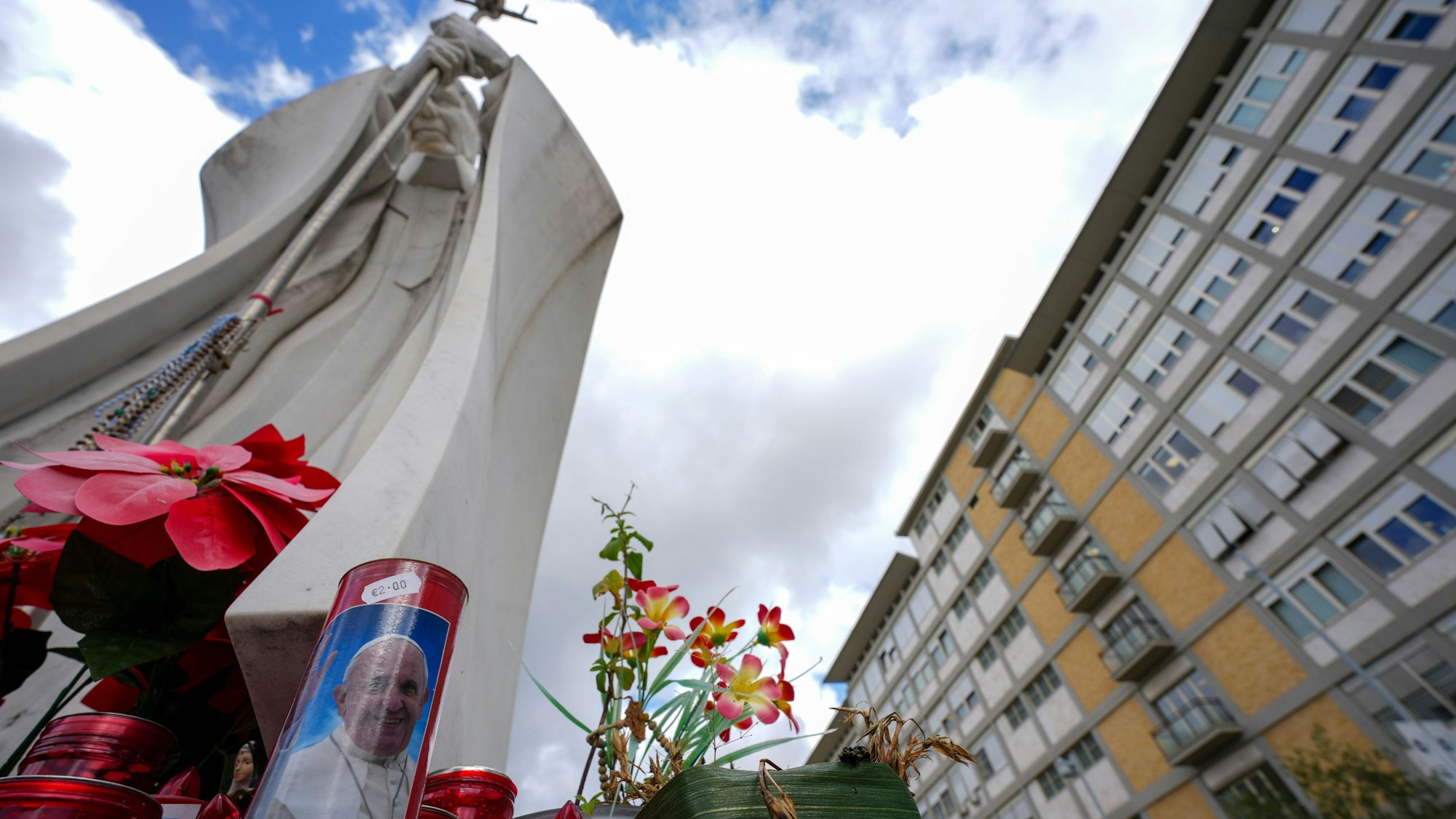 Kerzen, eine davon mit einem Foto von Papst Franziskus, stehen vor der Poliklinik Agostino Gemelli, wo Papst Franziskus ins Krankenhaus eingeliefert wurde, um sich einigen notwendigen diagnostischen Tests zu unterziehen und seine laufende Behandlung wegen Bronchitis fortzusetzen.