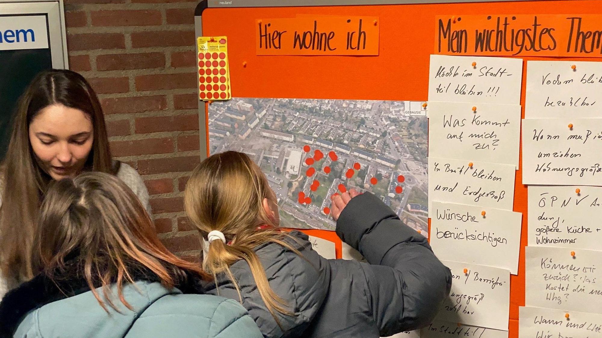 Zu sehen sind Bürgerinnen, die an einer Wand ihre Wünsche für das Quartier hinterlassen.