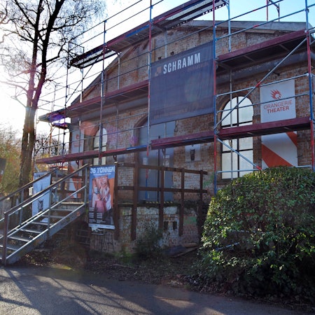 Die Baustellen-Fassade am Orangerie Theater im Volksgarten