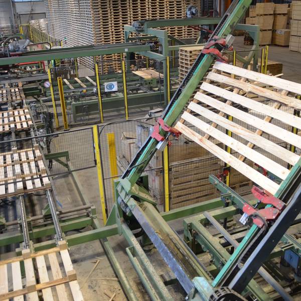 Ein Roboter wendet auf der Fertigungsstraße des Unternehmens Caspari in Waldbröl eine Holzpalette für die letzten Produktionsschritte. In sieben Sekunden ist eine solche Transporthilfe fertig.