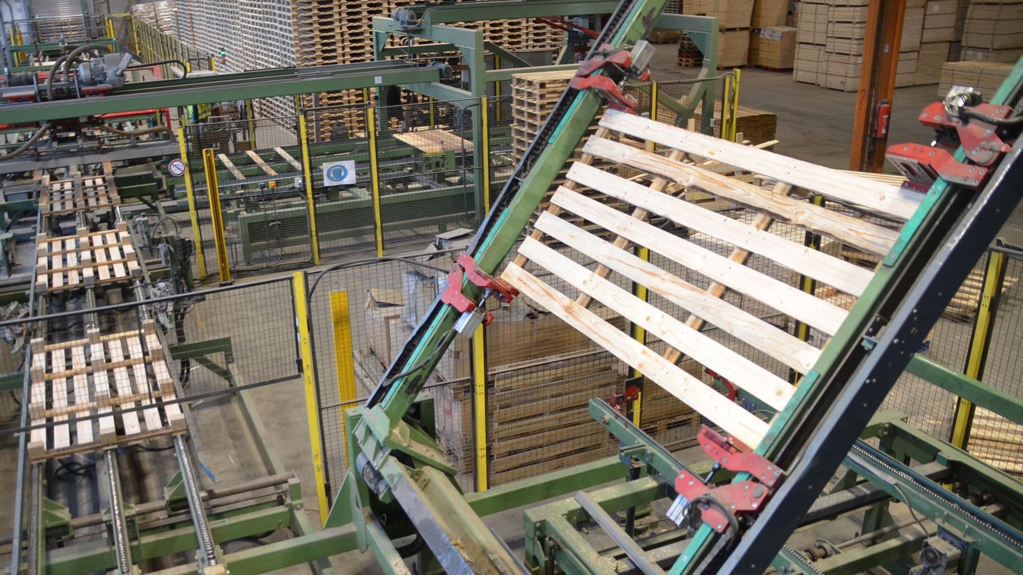 Ein Roboter wendet auf der Fertigungsstraße des Unternehmens Caspari in Waldbröl eine Holzpalette für die letzten Produktionsschritte. In sieben Sekunden ist eine solche Transporthilfe fertig.