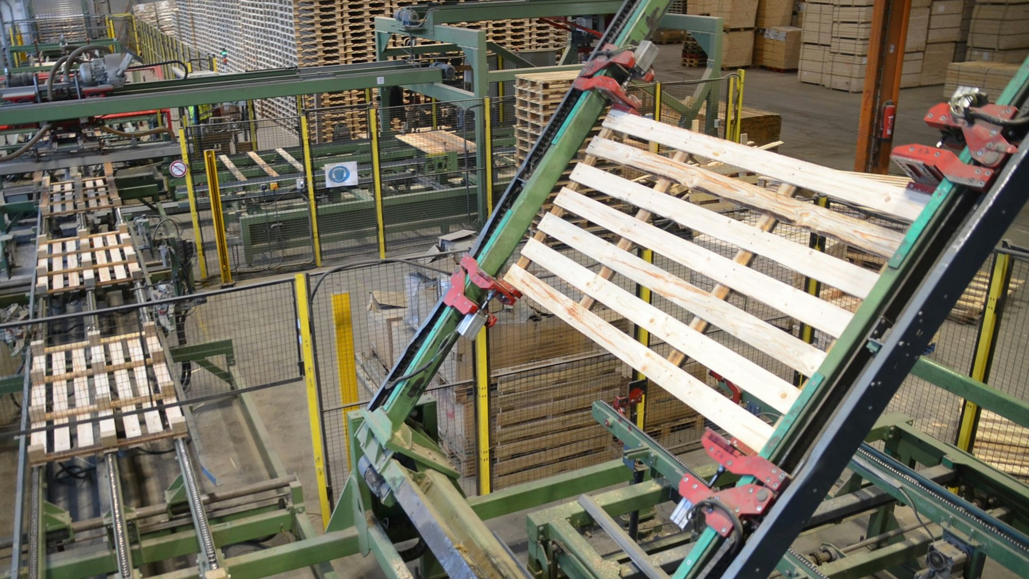 Ein Roboter wendet auf der Fertigungsstraße des Unternehmens Caspari in Waldbröl eine Holzpalette für die letzten Produktionsschritte. In sieben Sekunden ist eine solche Transporthilfe fertig.