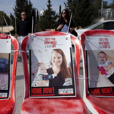 19.02.2025, Israel, Jerusalem: Plakate von Shiri Bibas und ihren Söhnen Ariel (l) und Kfir (r), die am 7. Oktober 2023 von Mitgliedern der Terrororganisation Hamas als Geiseln genommen wurden, sind auf Stühlen in Jerusalem befestigt.