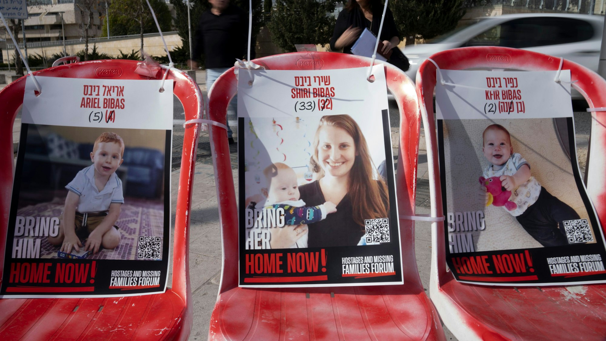 19.02.2025, Israel, Jerusalem: Plakate von Shiri Bibas und ihren Söhnen Ariel (l) und Kfir (r), die am 7. Oktober 2023 von Mitgliedern der Terrororganisation Hamas als Geiseln genommen wurden, sind auf Stühlen in Jerusalem befestigt.