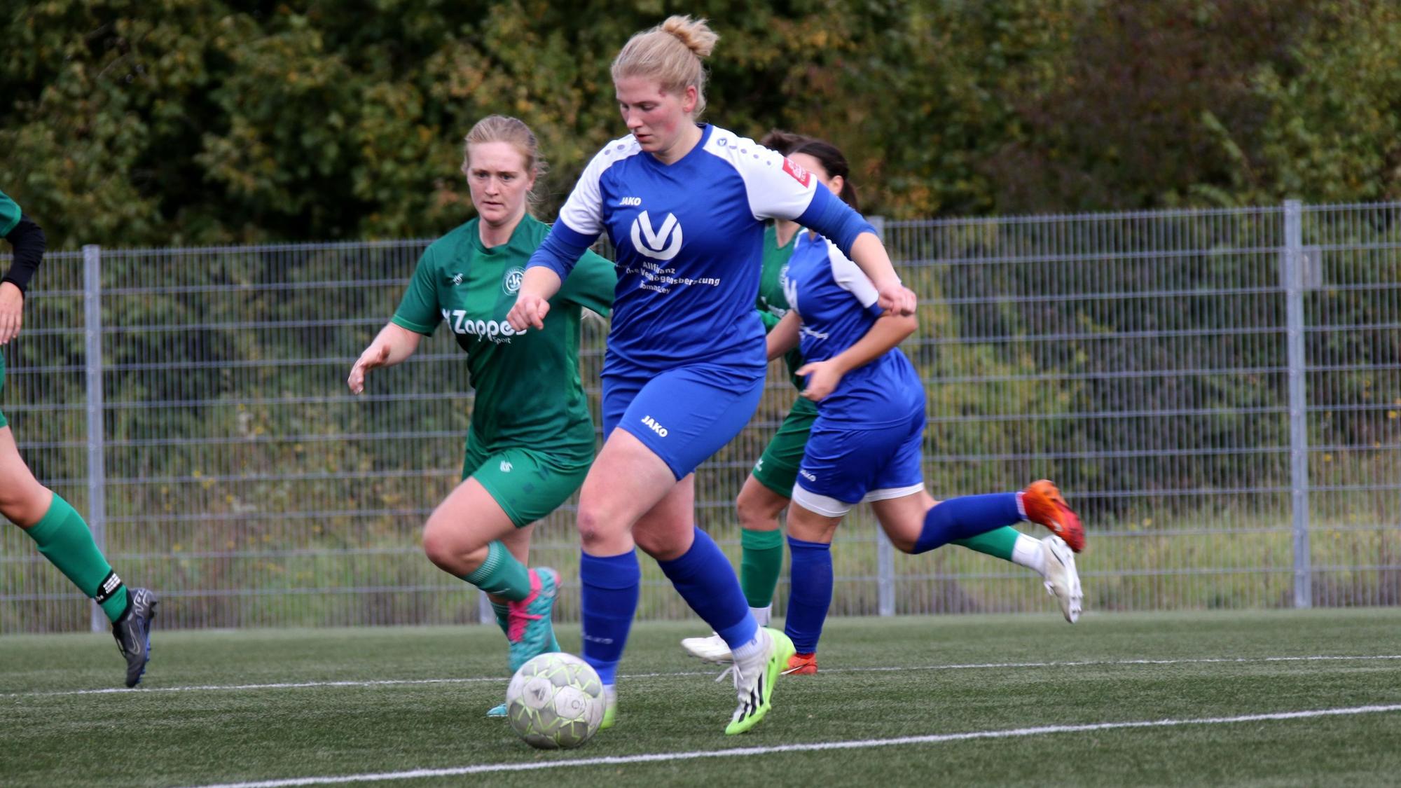 Julia Poth läuft mit dem Ball, eine Gegenspielerin versucht sie einzuholen.