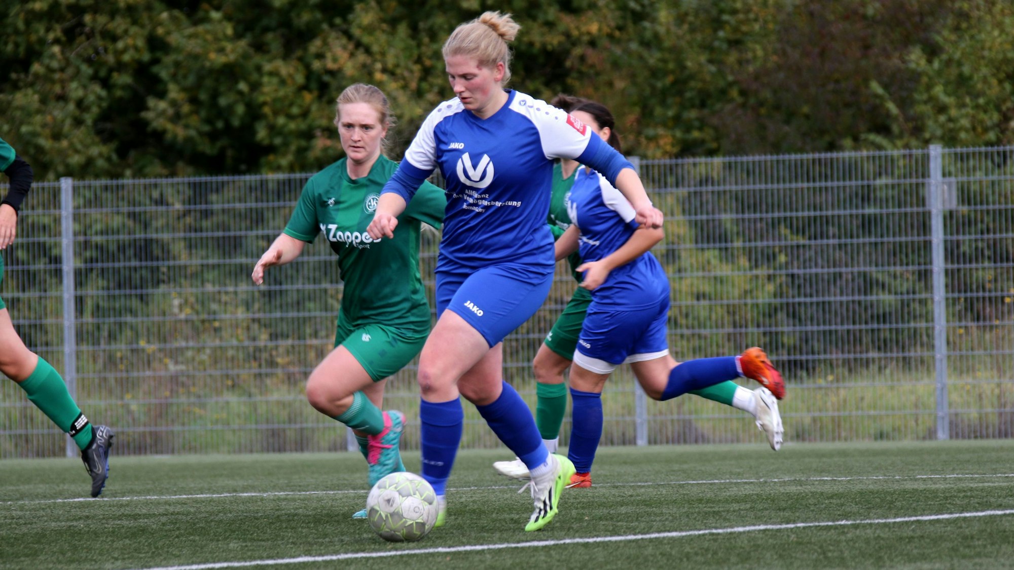 Julia Poth läuft mit dem Ball, eine Gegenspielerin versucht sie einzuholen.