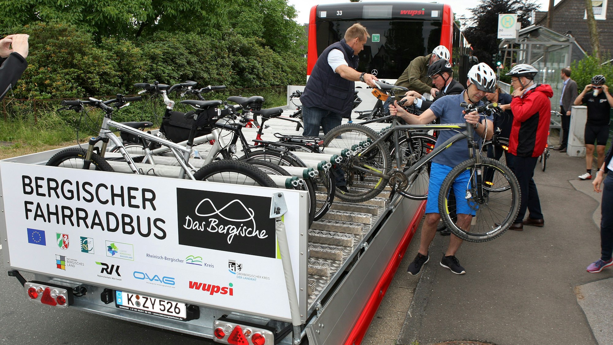 Fahrradfahrer laden Räder auf den Anhänger eines Bergischen Fahrradbusses in Wermelskirchen.
