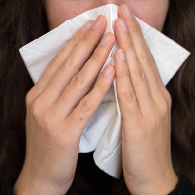 Eine Frau putzt sich die Nase. (Symbolbild)