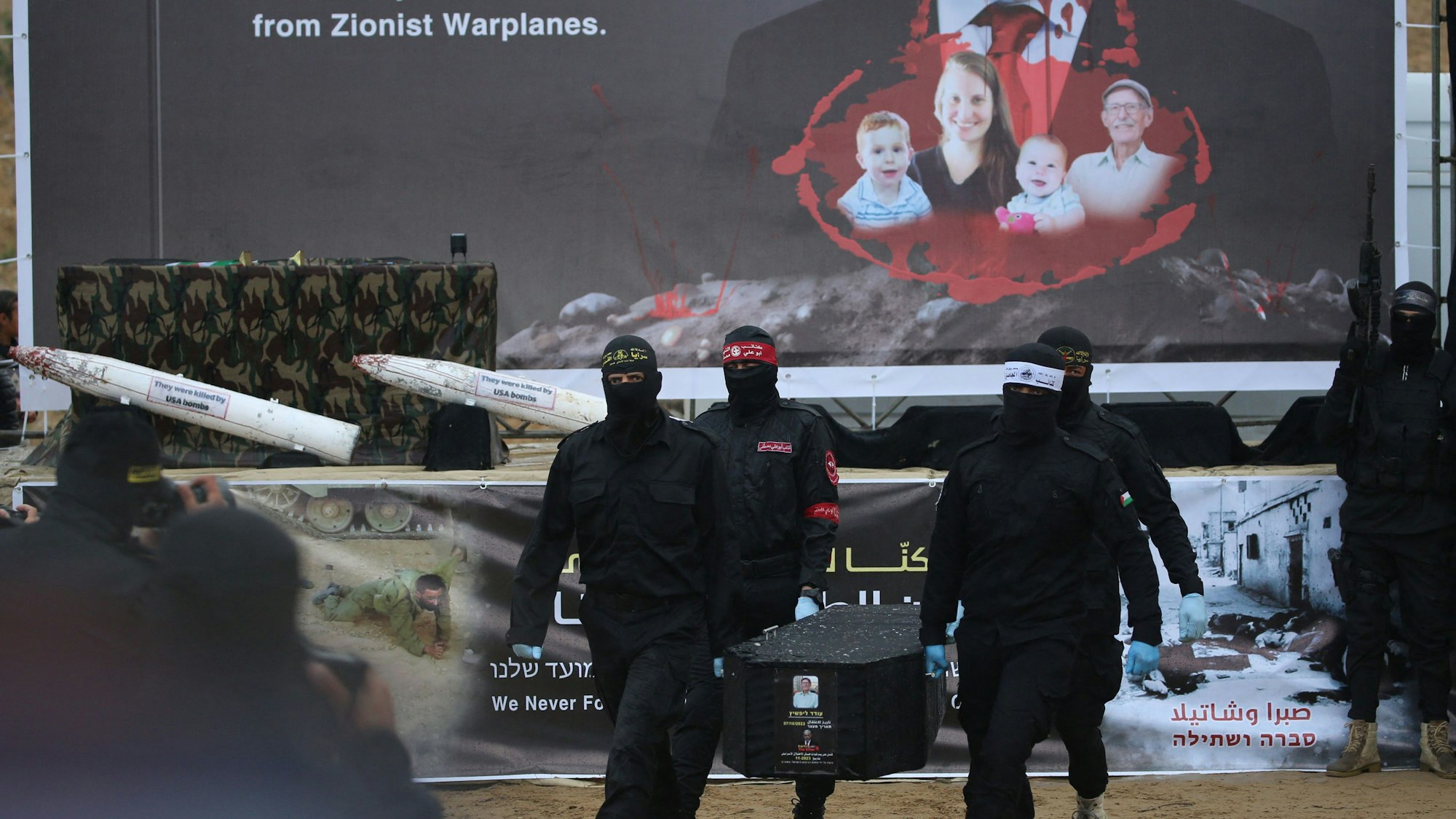 Palestinian militants carry one of the four coffins during the handing over of the bodies of four Israeli hostages to the Red Cross in Khan Yunis in the southern Gaza on February 20, 2025. Hamas handed over on February 20 coffins believed to contain the bodies of four Israeli hostages, including those of the Bibas family who became symbols of the ordeal that has gripped Israel since the Gaza war began. The transfer of the bodies is the first by Hamas since its October 7, 2023 attack on Israel triggered the war, and is taking place under a fragile ceasefire that has seen living hostages exchanged for Palestinians held in Israeli prisons. (Photo by Eyad BABA / AFP)