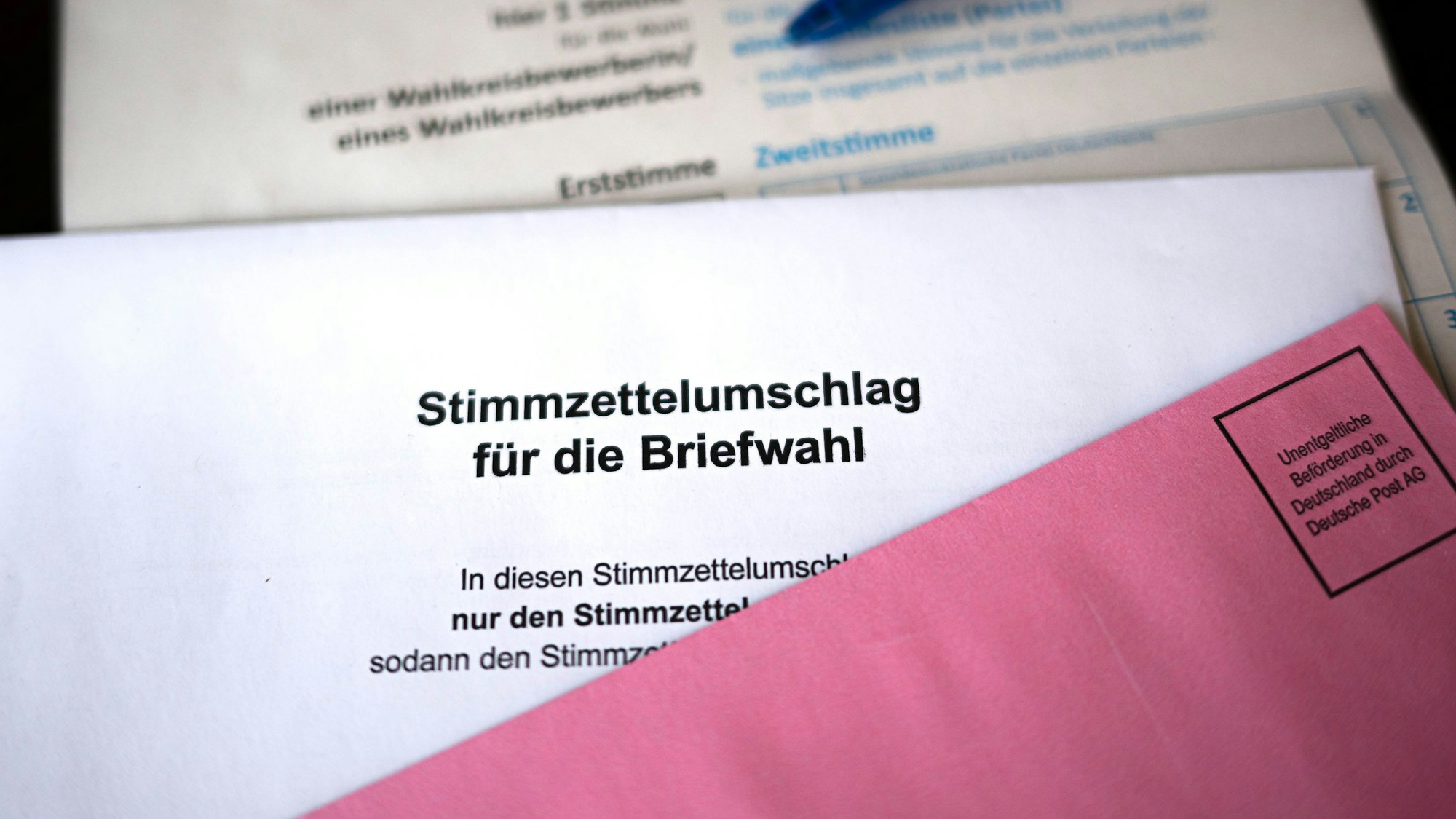 Briefwahlunterlagen liegen auf einem Tisch.