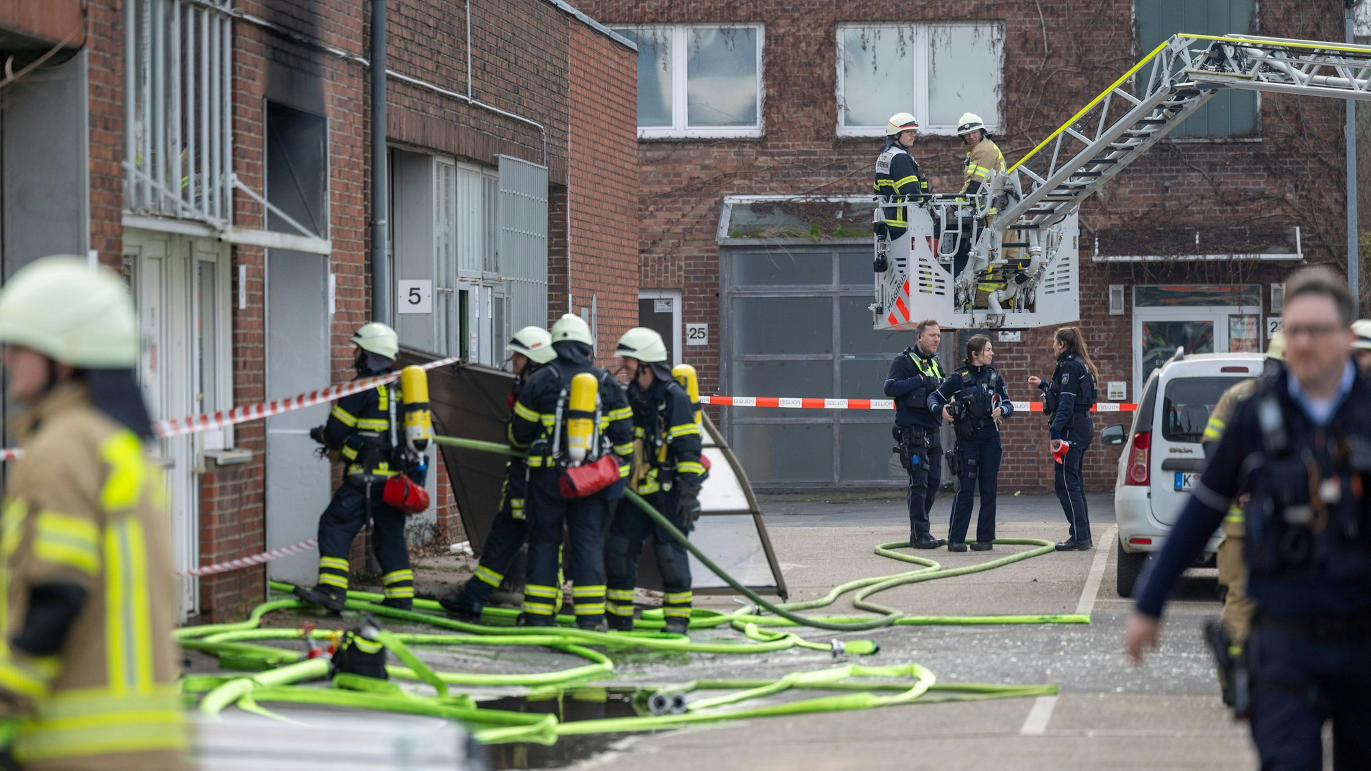 Feuerwehrleute bekämpfen den Brand nach einer Explosion in einer Lagerhalle