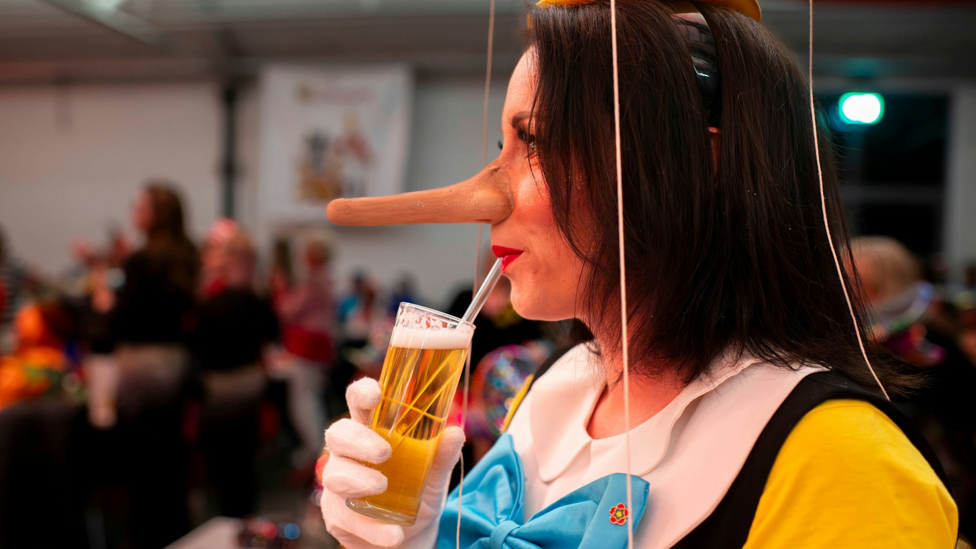 Das Bild zeigt Stephanie Kuhnert, wie sie mithilfe eines Glasstrohhalms ein Kölsch trinkt.