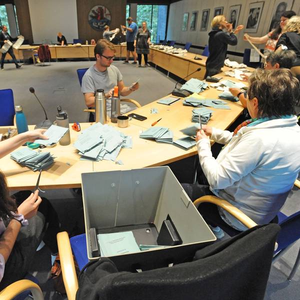 Wahlhelfer zählen nach einer Wahl Stimmzettel aus.