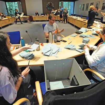 Wahlhelfer zählen nach einer Wahl Stimmzettel aus.