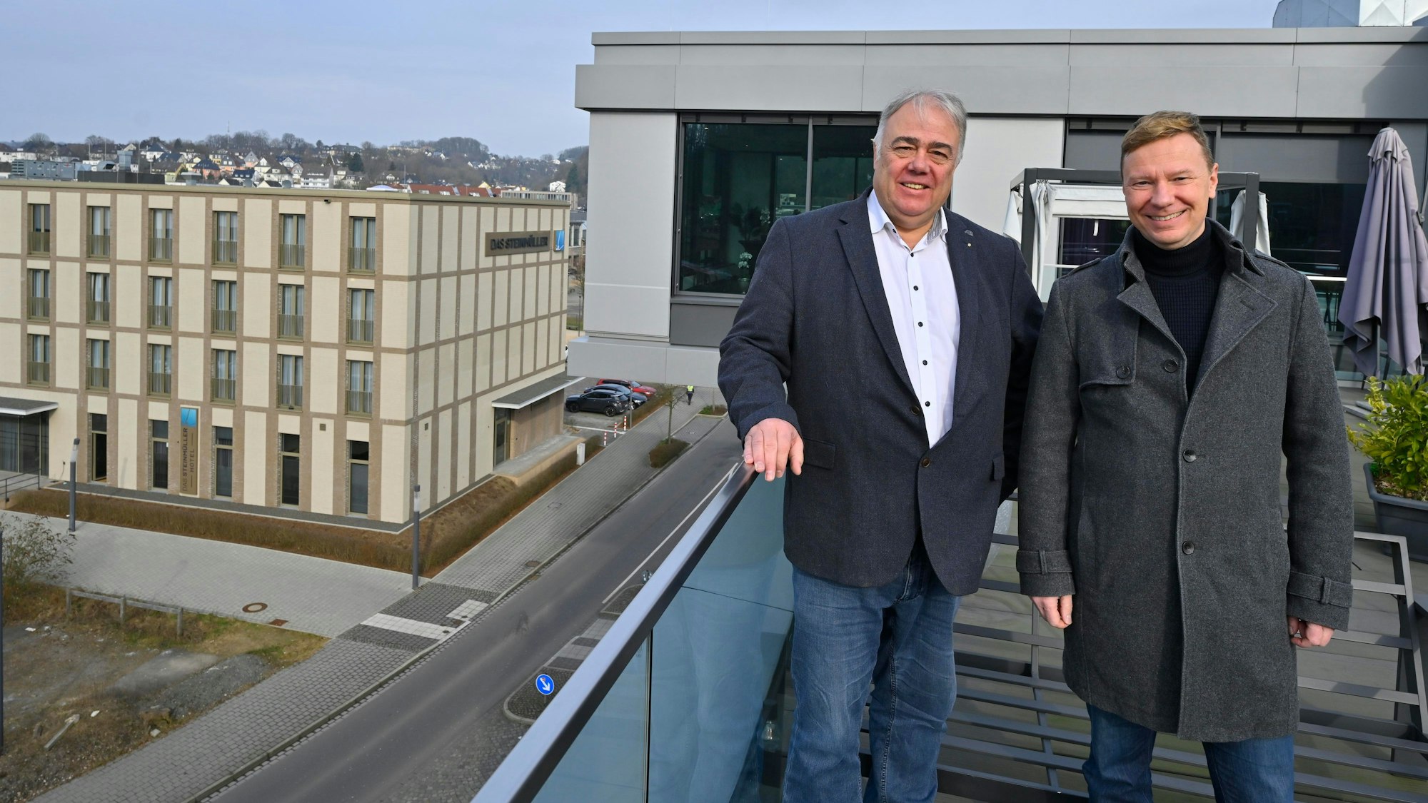 Zwei Männer stehen auf der Dachterrasse einer Skybar in Gummersbach.