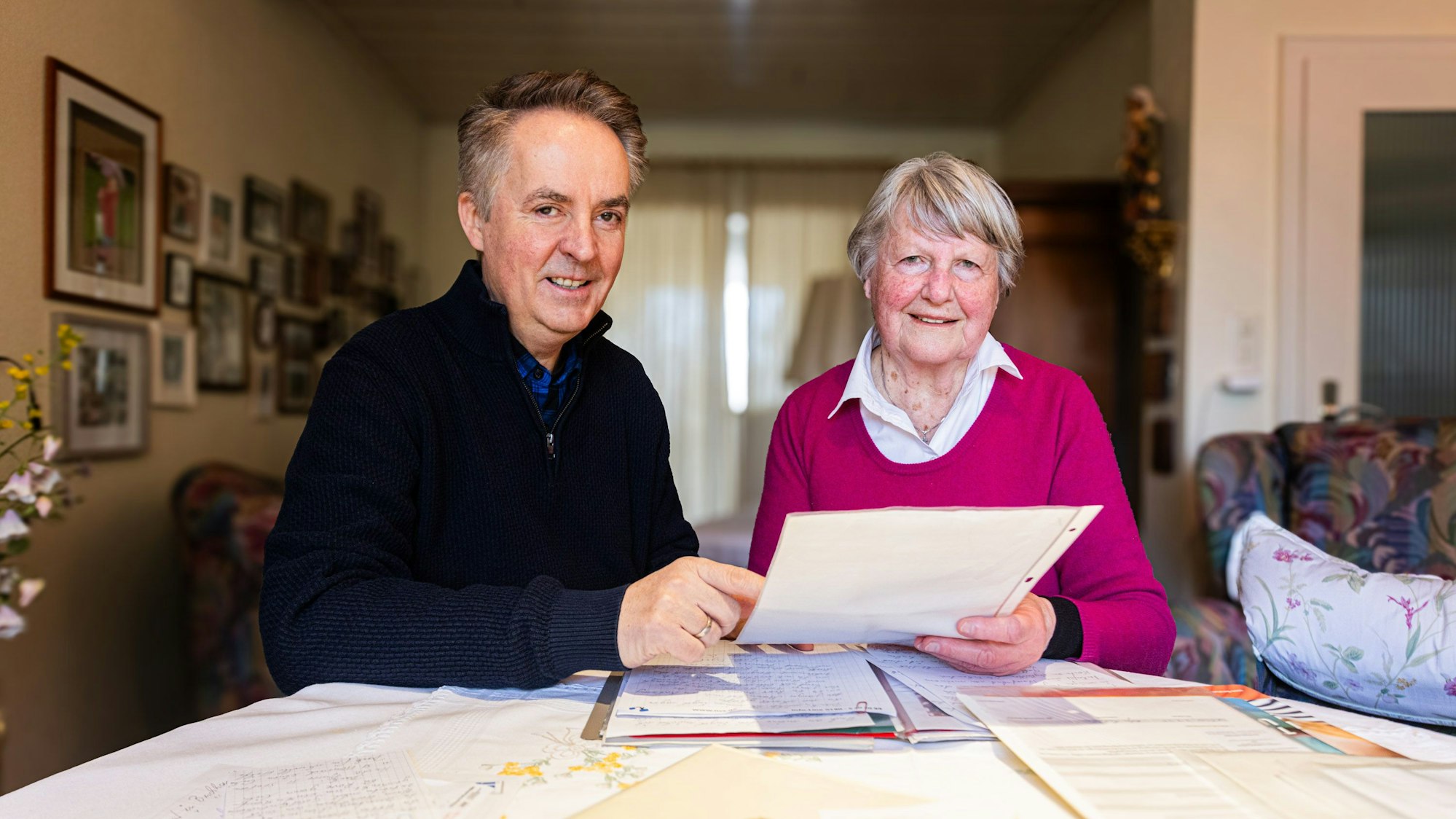 Helga Euskirchen und Michael Kokott sitzen an einem Tisch und halten Blätter in den Händen