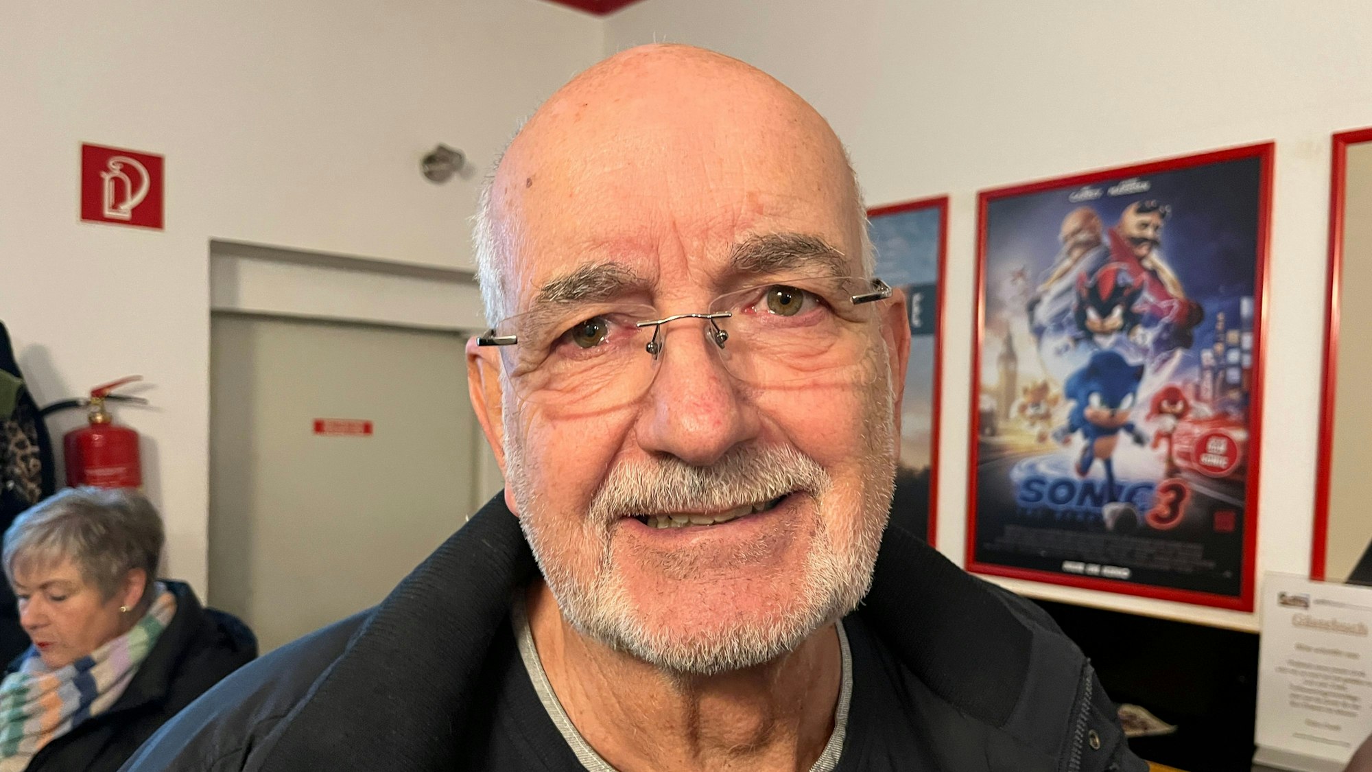 Ein Mann steht in einem Kino im Foyer.