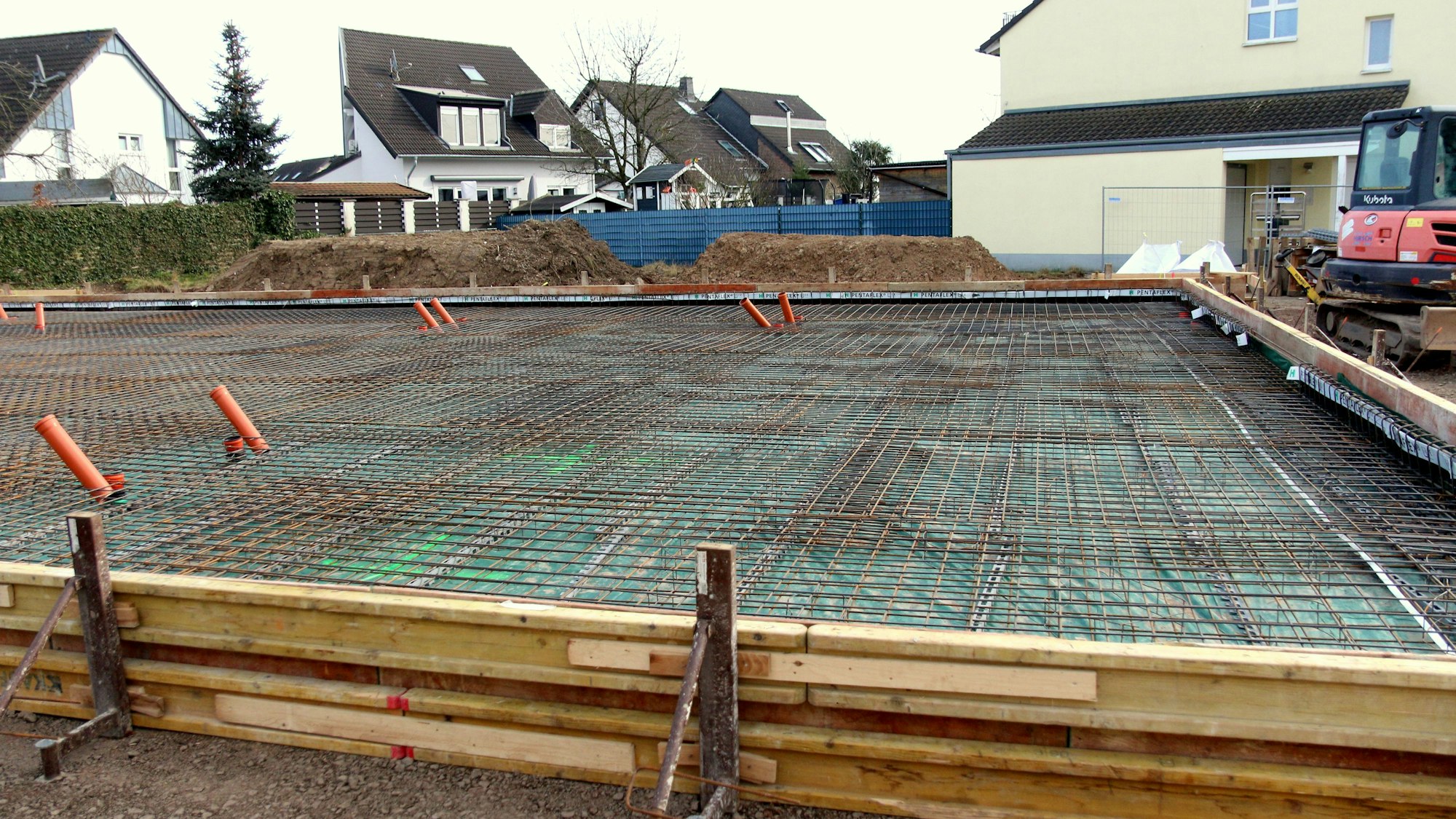 Eine Baustelle, im Hintergrund Wohnhäuser.