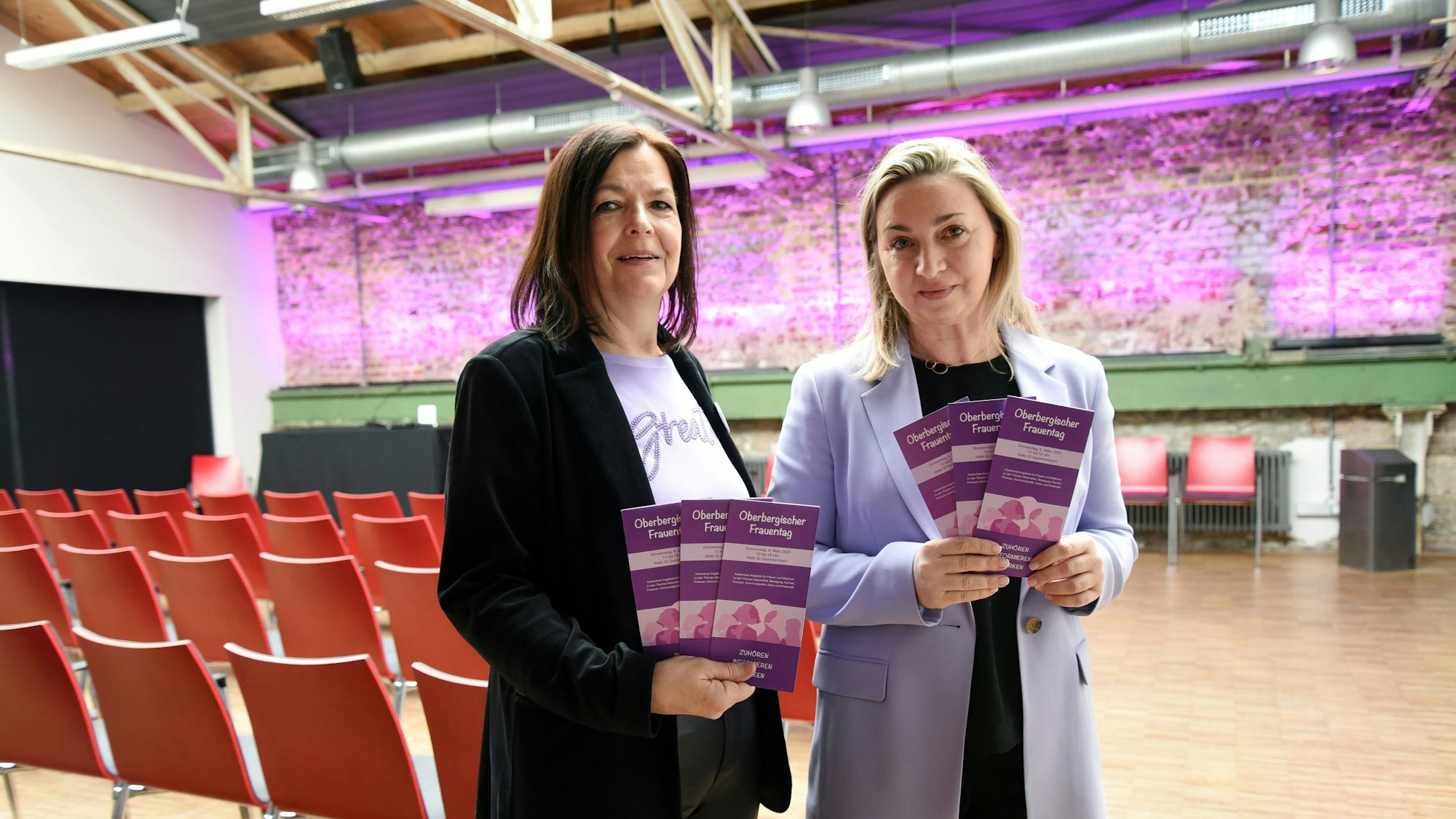 Zwei Frauen halten Flyer in der Hand.