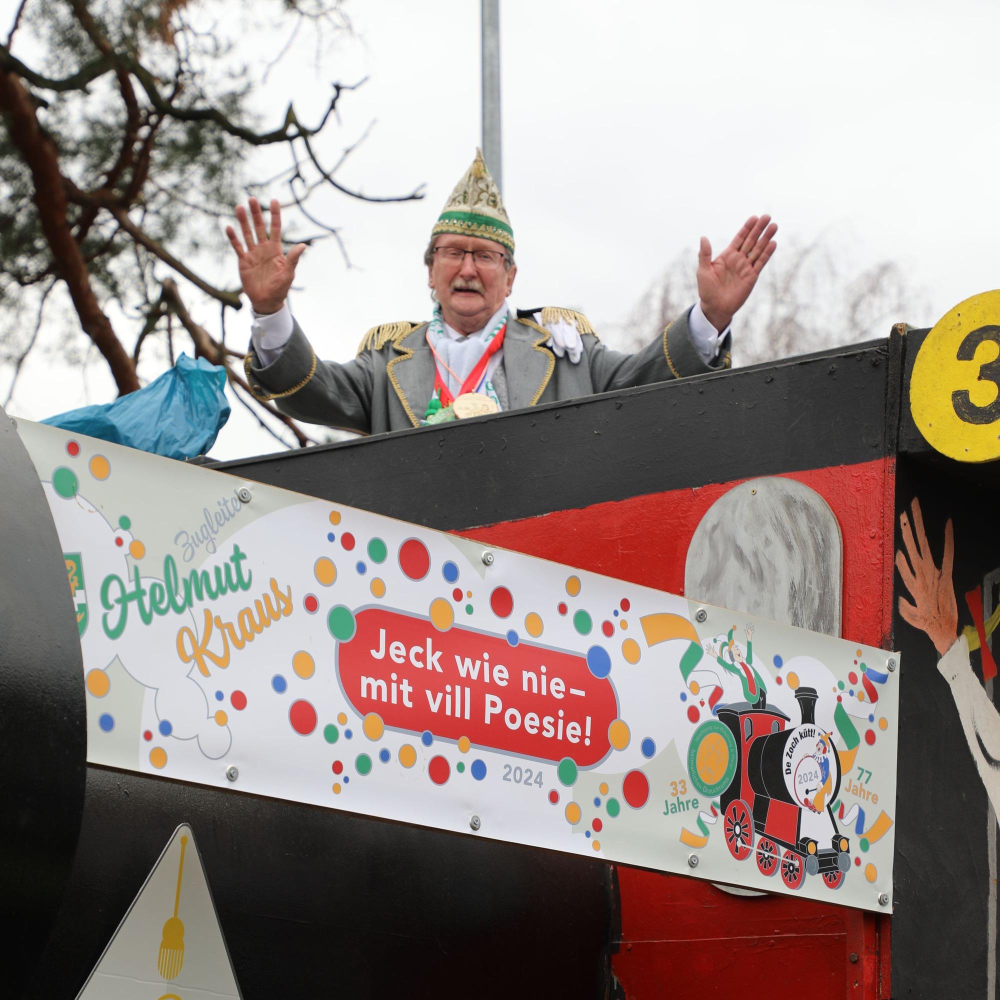 Helmut Kraus steht auf seinem Zugleiter-Wagen und breitet die Arme aus.