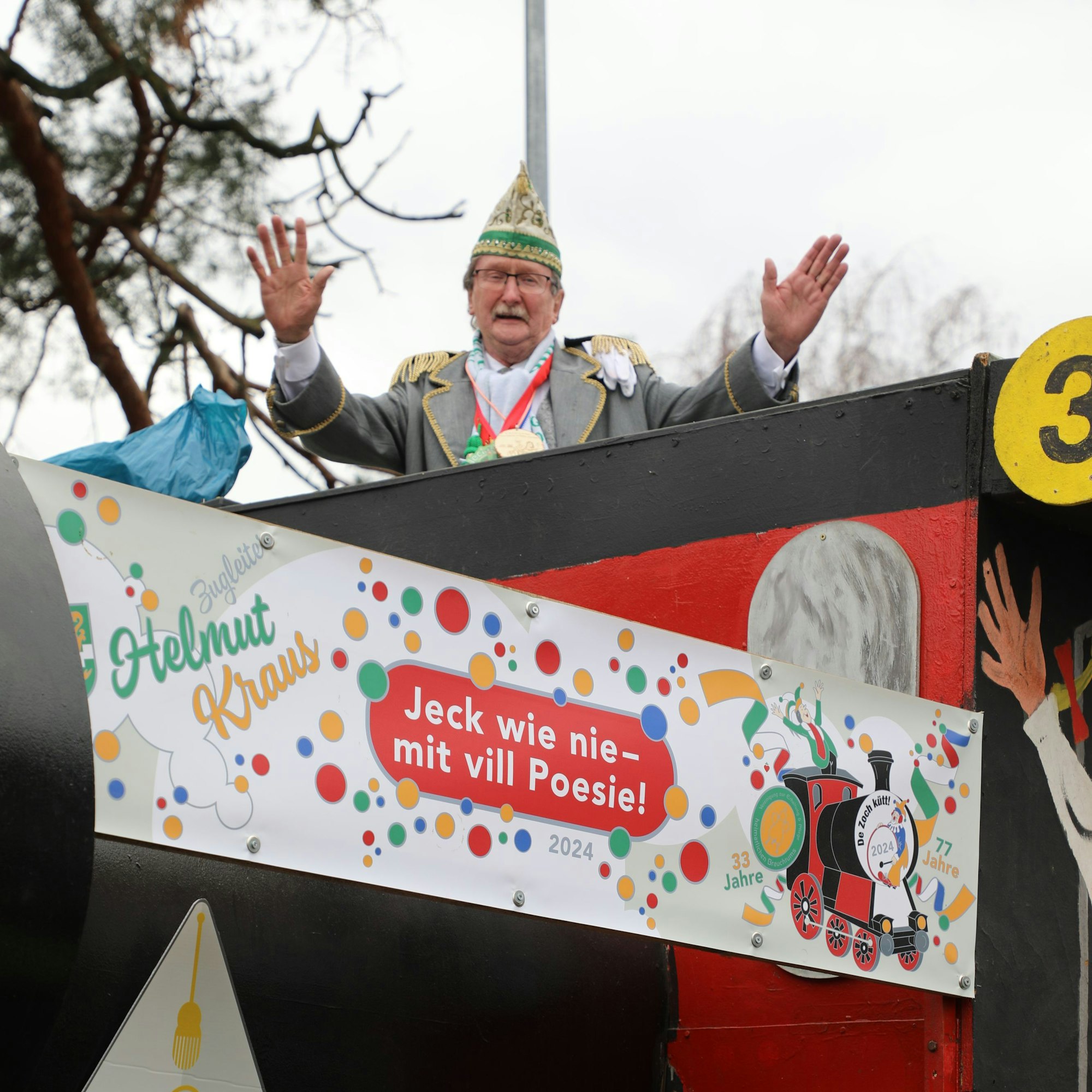 Helmut Kraus steht auf seinem Zugleiter-Wagen und breitet die Arme aus.