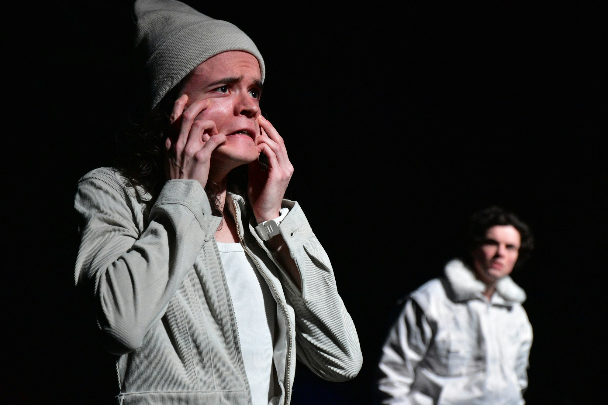 Zwei in grau gekleidete Schauspieler.