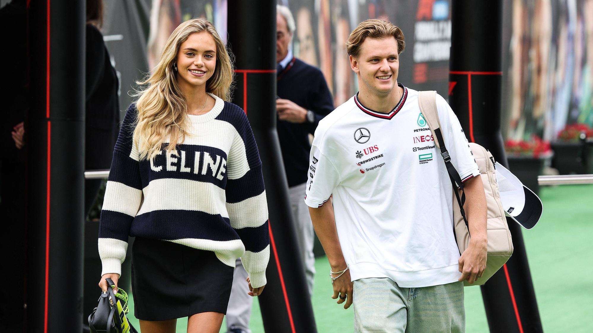 Mick Schumacher und seine Freundin Laila Hasanovic betreten das Fahrerlager.
