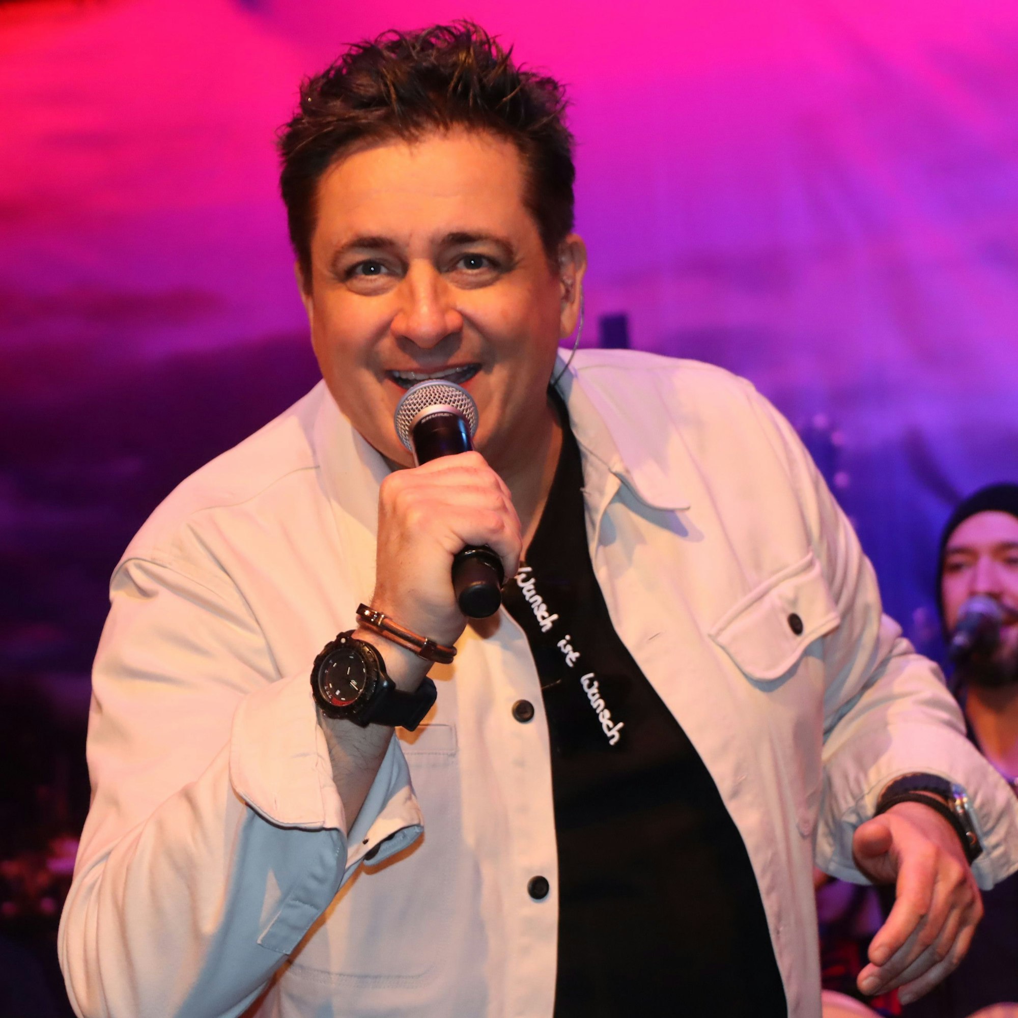 Ein Mann singt in ein Mikrofon.