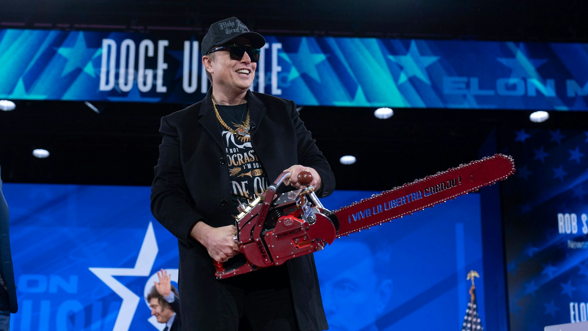 dpatopbilder - 20.02.2025, USA, Oxon Hill: Elon Musk hält eine Kettensäge, als er bei der Conservative Political Action Conference (CPAC) im Gaylord National Resort & Convention Center ankommt. Foto: Jose Luis Magana/AP/dpa +++ dpa-Bildfunk +++