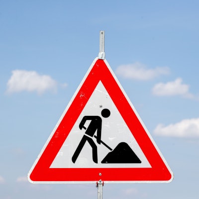 Ein Baustellenschild vor blauem Himmel.